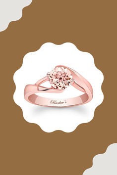 a pink diamond ring on a brown and white background