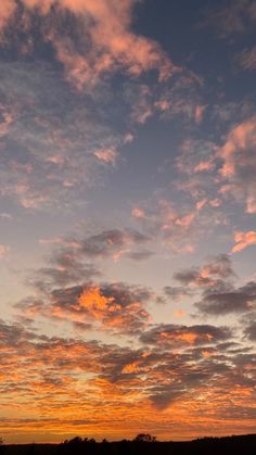 an airplane flying in the sky at sunset