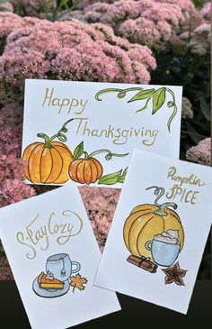 three thanksgiving cards with pumpkins and coffee on them, sitting in front of some flowers