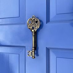 an old key is hanging on the blue door