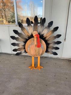 a wooden turkey standing in front of a window