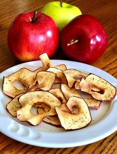 apples and cinnamon chips on a white plate with an apple in the back ground next to them