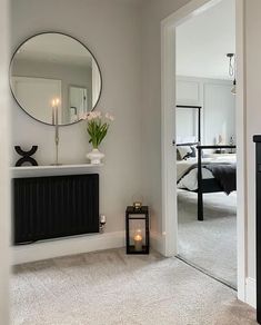 a room with a fireplace, mirror and lamp on the wall in front of it