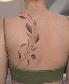 the back of a woman's shoulder with leaves on it