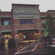 the outside of a book store with cars parked in front