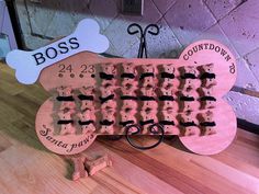 a dog bone shaped waffle board with the words boss on it and two pairs of scissors next to it