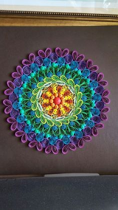 a colorful paper doily is displayed on the wall