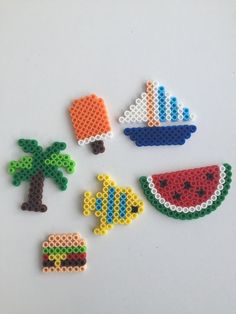 four pieces of perler bead art on a white surface with palm trees, watermelon and boat