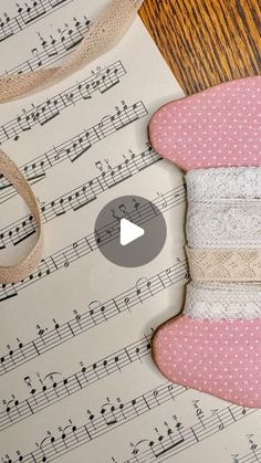 a video demonstrating how to make an origami hat with music sheets and ribbon