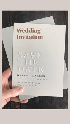 someone holding up some white cards with the words save the date written on them in silver foil