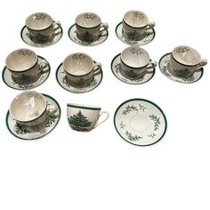 twelve teacups and saucers with green trim around the edges, all in different designs