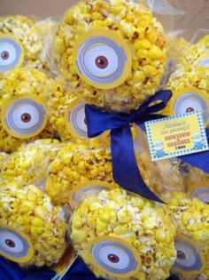 some kind of yellow popcorn with eyes on it and a blue ribbon around the top