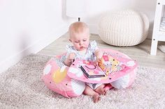 a baby sitting on the floor playing with a toy