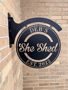 a sign on the side of a building that says she shed est 2092 and is hanging from the wall