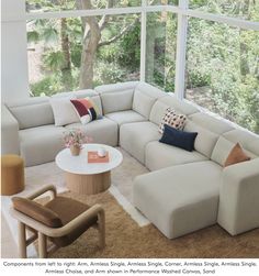 a living room with a large sectional couch and coffee table in front of the window