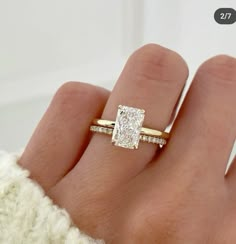 a woman's hand with a diamond ring on top of her finger and an engagement band