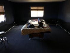 an empty room with a bed and two chairs