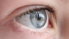 a close up view of a child's blue eye