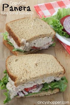 two sandwiches cut in half sitting on top of a cutting board