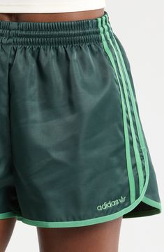 Lightweight and comfortable, these shorts made of recycled fibers sport dolphin hems for easy movement. 2 1/2" inseam; 28" leg opening; 12" front rise; 16 1/2" back rise (size Small) Elastic waist 100% recycled polyester Machine wash, line dry Imported Adidas Logo Shorts For Sports In Spring, Adidas Logo Sports Shorts For Spring, Adidas Sportswear Shorts For Spring, Adidas Logo Sportswear Shorts For Spring, Spring Sports Shorts With Adidas Logo, Adidas Logo Athleisure Bottoms For Summer, Three Stripes Gym Bottoms For Summer, Summer Athleisure Shorts With Adidas Logo, Adidas Logo Short Bottoms For Summer