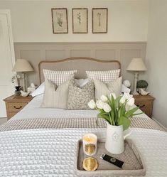 a tray with flowers and candles on a bed