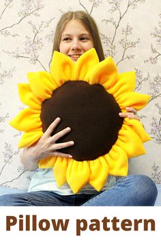 a girl holding a large sunflower pillow in front of her face with the words pillow pattern on it