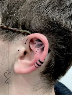 a man with black and white designs on his ears is wearing a pair of ear piercings