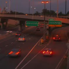 cars are driving down the highway at night