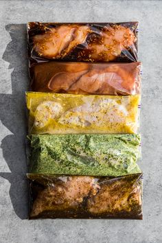 four different types of food wrapped in plastic on top of each other and placed next to each other