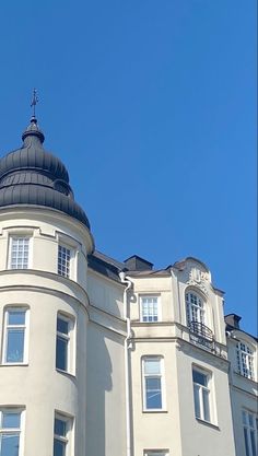 a large white building with a clock on it's face in front of a blue sky