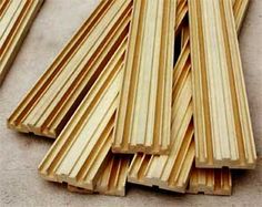 several pieces of wood sitting on top of a cement floor next to a pile of wooden planks