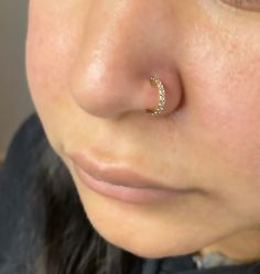 a close up of a person's nose with a gold nose ring on it