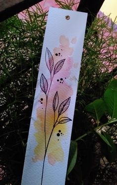 a piece of paper that has some flowers on it with watercolor paint in the background