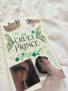 the cruel prince book is open on a bed with white sheets and green beads around it