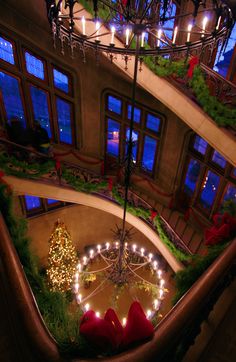 an upside down view of a christmas tree in the middle of a building with lights on it