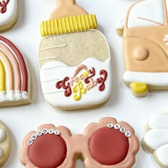 decorated cookies are arranged in the shape of cars and rainbows, with sunglasses on them