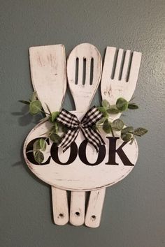 a sign that says cook with utensils and greenery in the shape of spoons