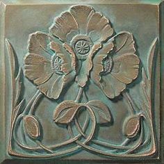 a decorative tile with flowers and leaves on it