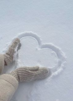 a teddy bear laying in the snow with a heart drawn on it's side