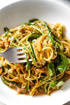 a white bowl filled with noodles and vegetables