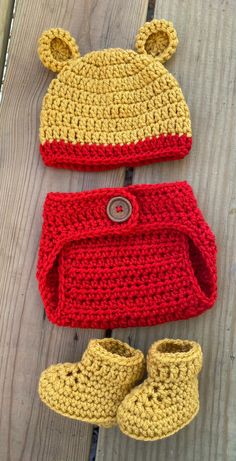 two crocheted baby hats and booties are laying on a wooden surface together