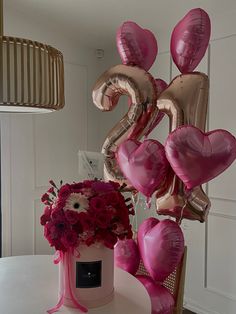 a table topped with balloons and flowers on top of it