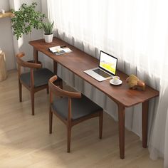 a laptop computer sitting on top of a wooden desk next to two chairs and a potted plant