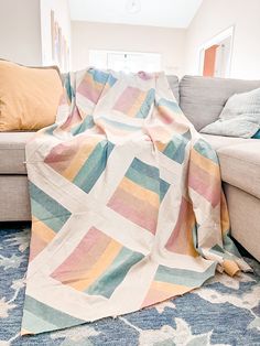 a living room with a couch and a blanket on the floor