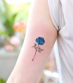 a blue rose tattoo on the arm