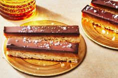 three pieces of chocolate and peanut butter sandwich on two gold plates next to each other