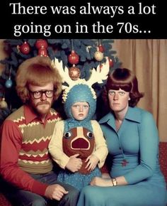 an old photo of two adults and a child with reindeer head on their heads sitting in front of a christmas tree