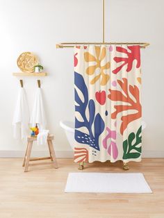 a bathroom with a shower curtain and rug on the floor next to it is a white bath tub