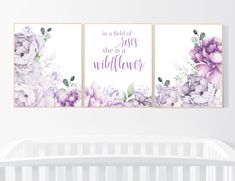 three purple flowers are on the wall next to a crib in a white room