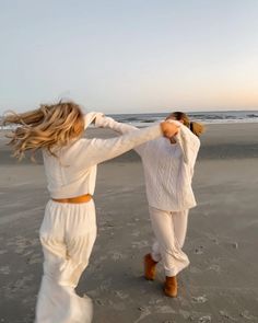 two women are walking on the beach together